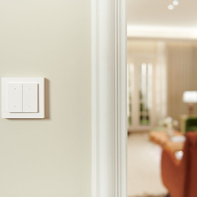 Light switch on a wall with a blurred living room in the background