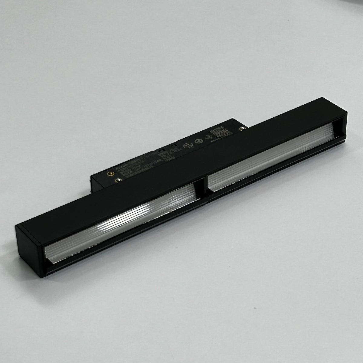 A close-up shot of the Aqara H1 Pro Recessed Track Polarized Light (10W), showcasing its unique, angled optical design and sleek black finish. The image emphasizes the specialized lens technology that creates the distinctive 'polarized' light effect.