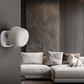 A wall mounted Presence Sensor FP1E
 in front of a modern living room with a gray sofa.