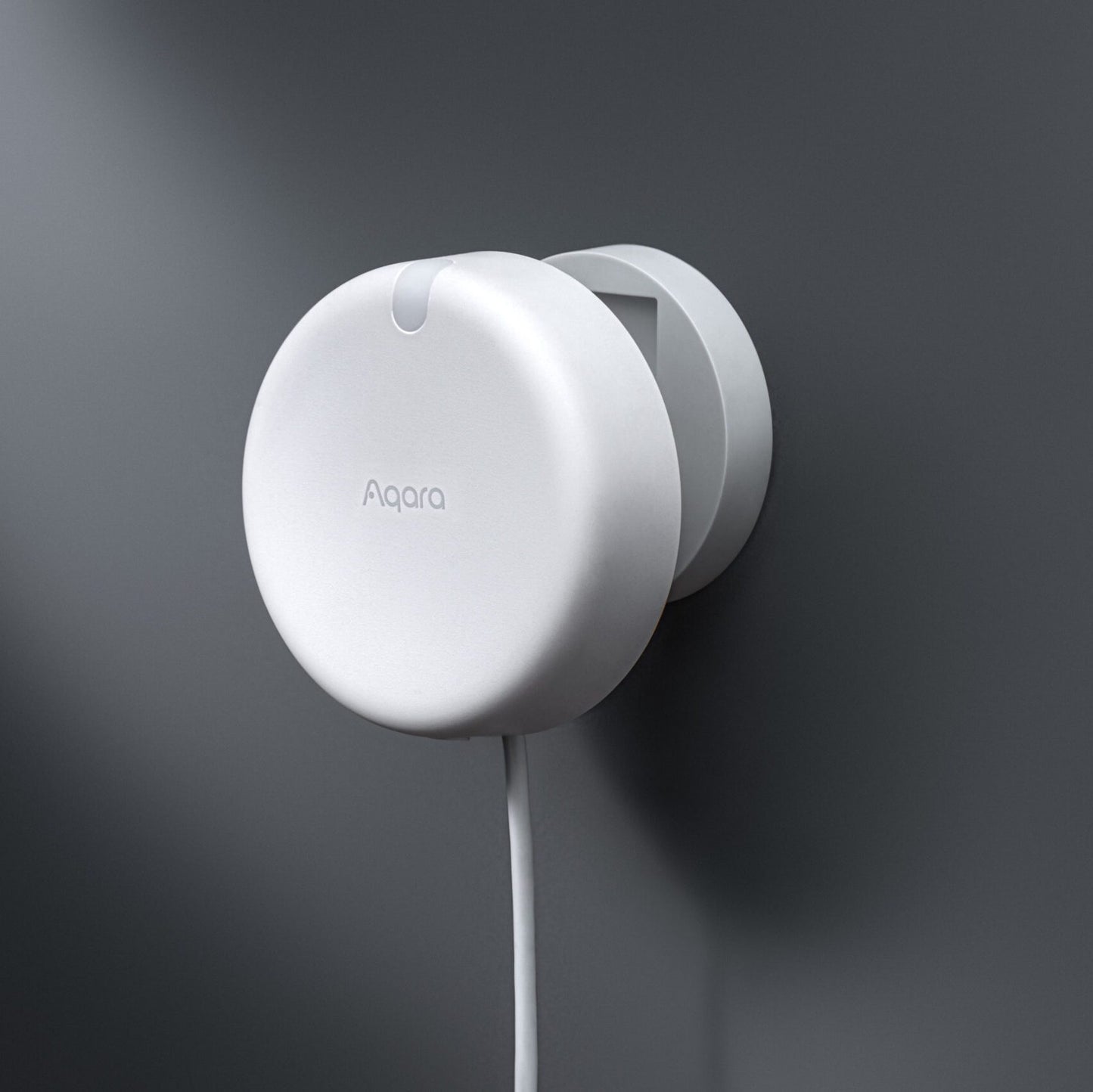 A white Presence Sensor FP2 Angle Mount mounted on a dark gray wall