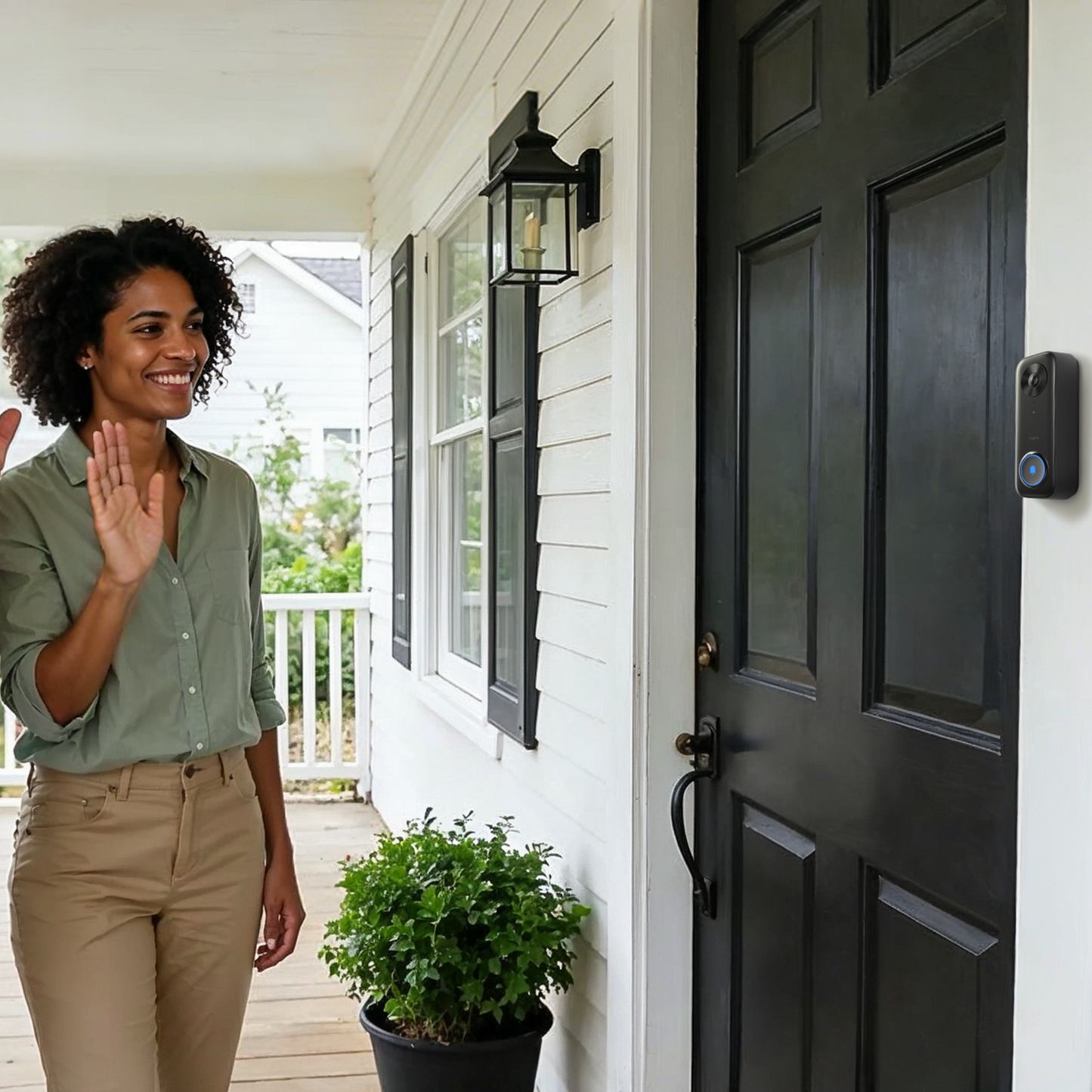 Woman waving at the Wired Doorbell Camera G400 on a porch